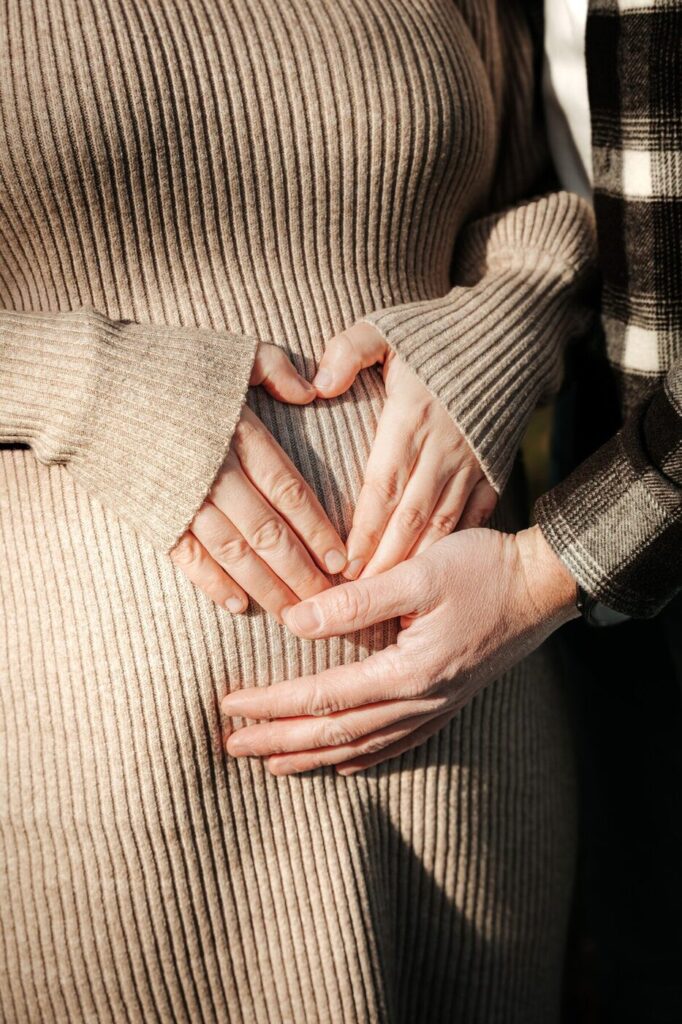 Mains en forme de cœur sur un ventre de femme enceinte, photographe grossesse à Vevey